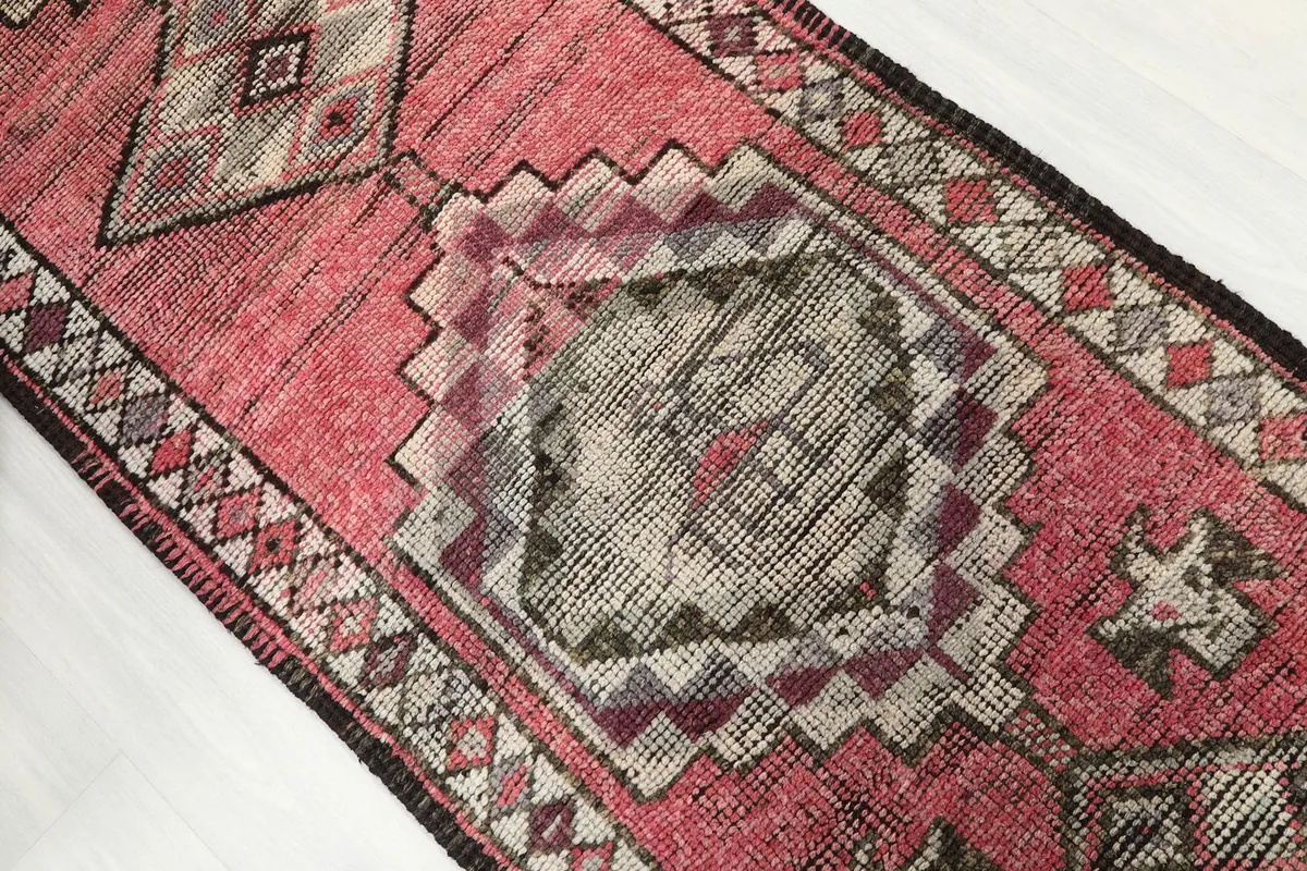 Close-up of a central geometric motif with rose, gray, and brown tones