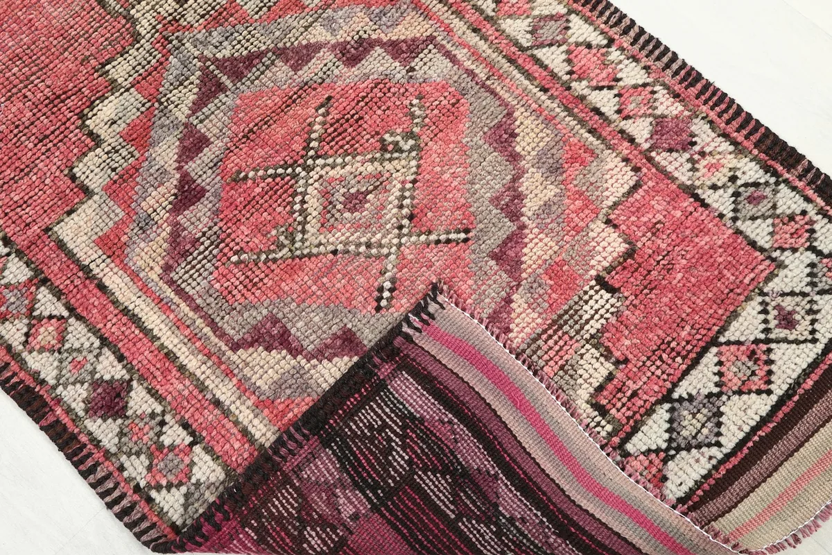 View of the back of the rug, showing the cotton foundation and knotting