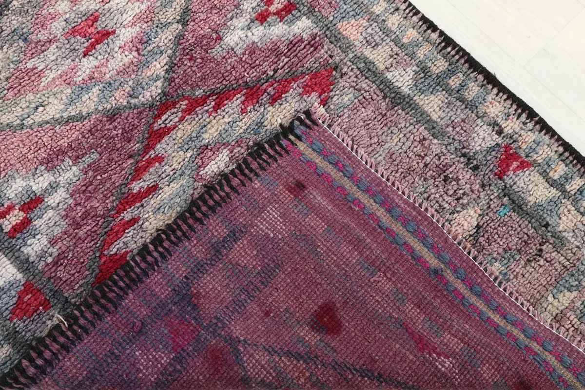 View of the rug's back, showing the hand-knotted cotton foundation and wool pile construction.