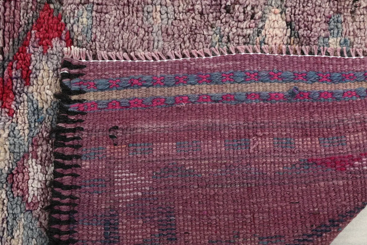 Close-up of the back of the rug, detailing the tight knotting and woven cotton foundation.