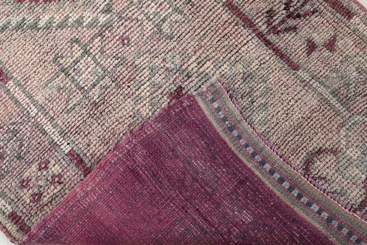View of the back of the hand-knotted wool rug, revealing the cotton foundation and knotting