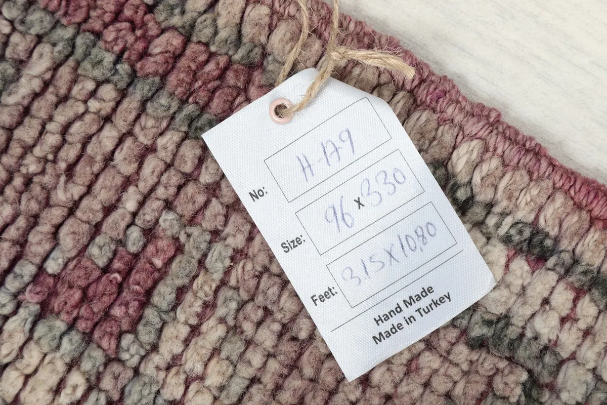 Tag showing the rug's dimensions in centimeters and feet, confirming it is hand made in Turkey