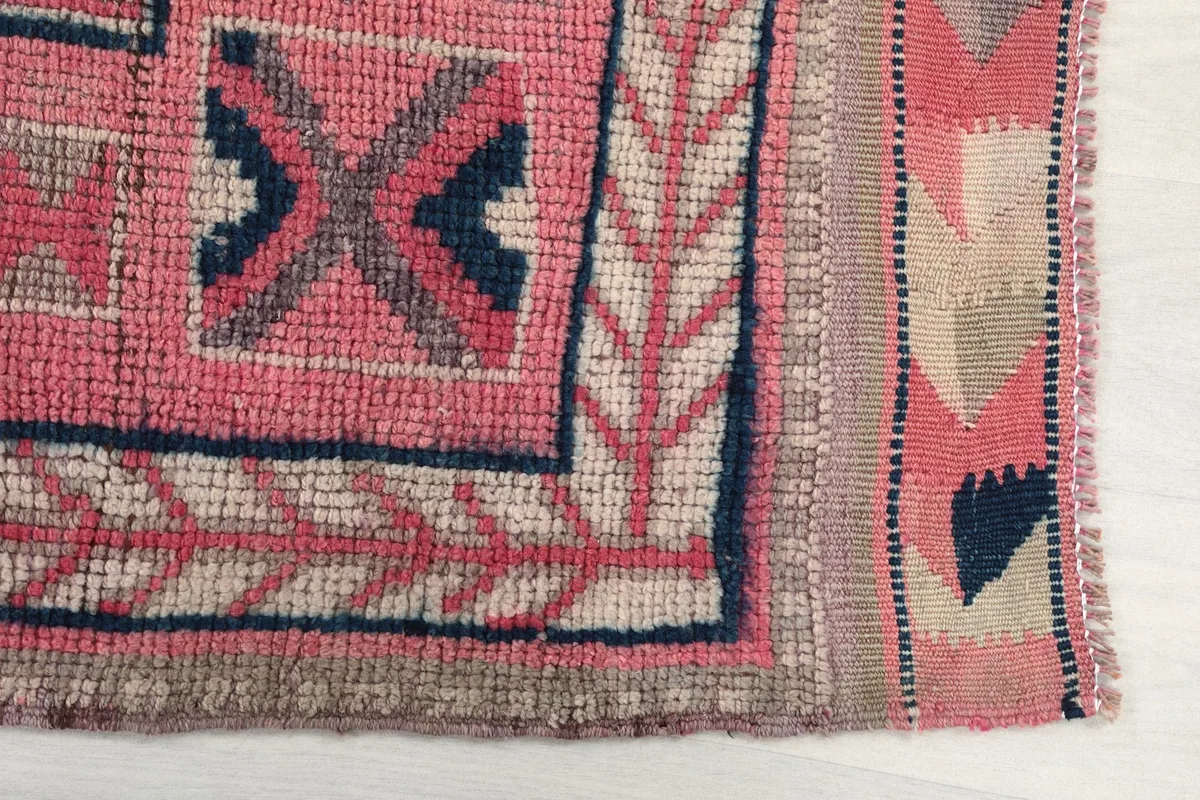Detailed view of the rug's edge and border, showcasing the hand-knotted texture and patterns