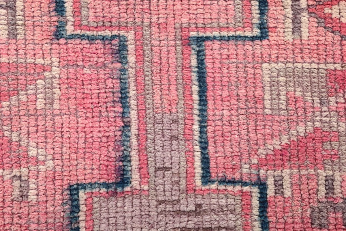 Close-up of the low wool pile, showing the texture and color variations of rose and gray