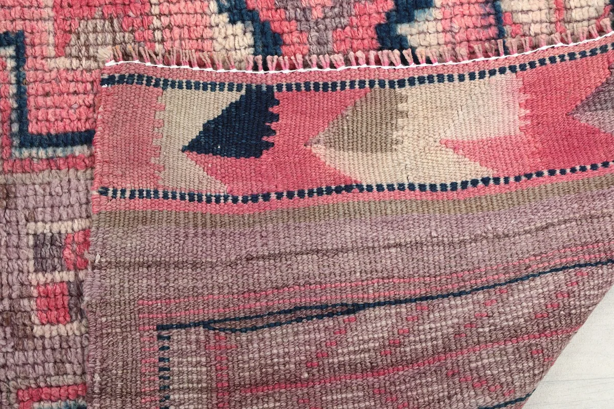 Close-up of the rug's reverse side, showing the dense knotting and end finishes
