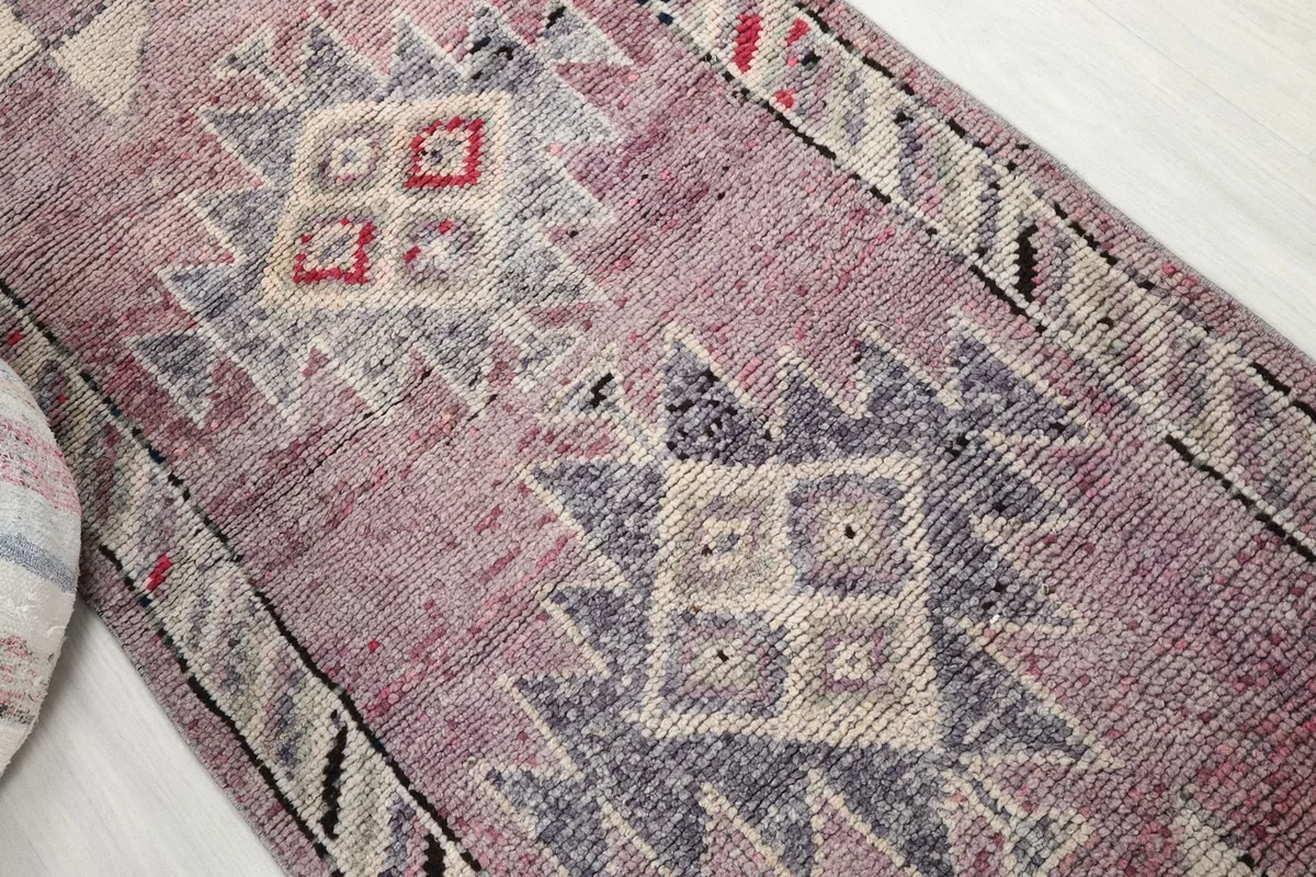Close-up of the central tribal geometric motifs in rose, ivory, gray, and red