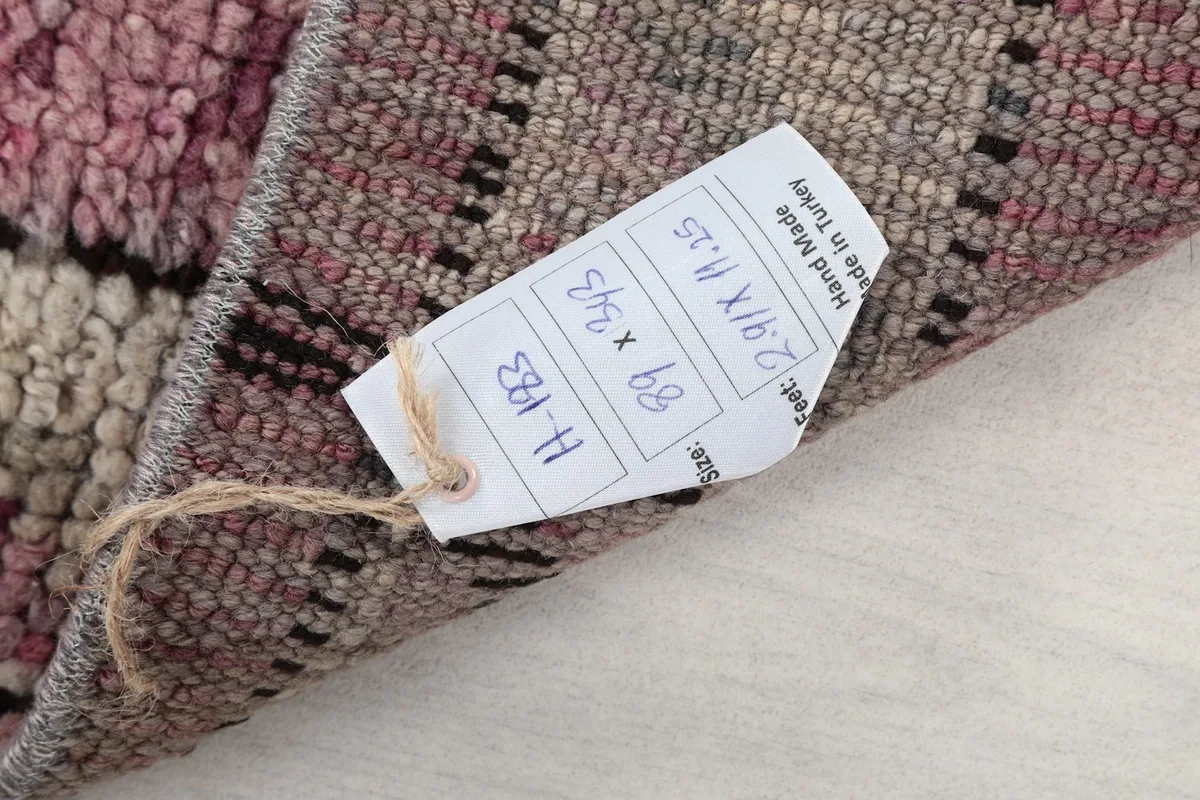 Product tag showing the rug's dimensions and origin, attached to the back of the rug