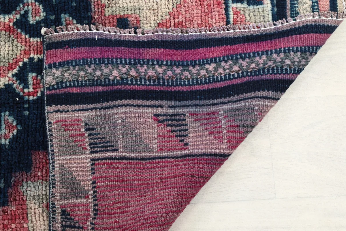 Close-up of the rug's back, showing the consistent knotting and the cotton foundation material