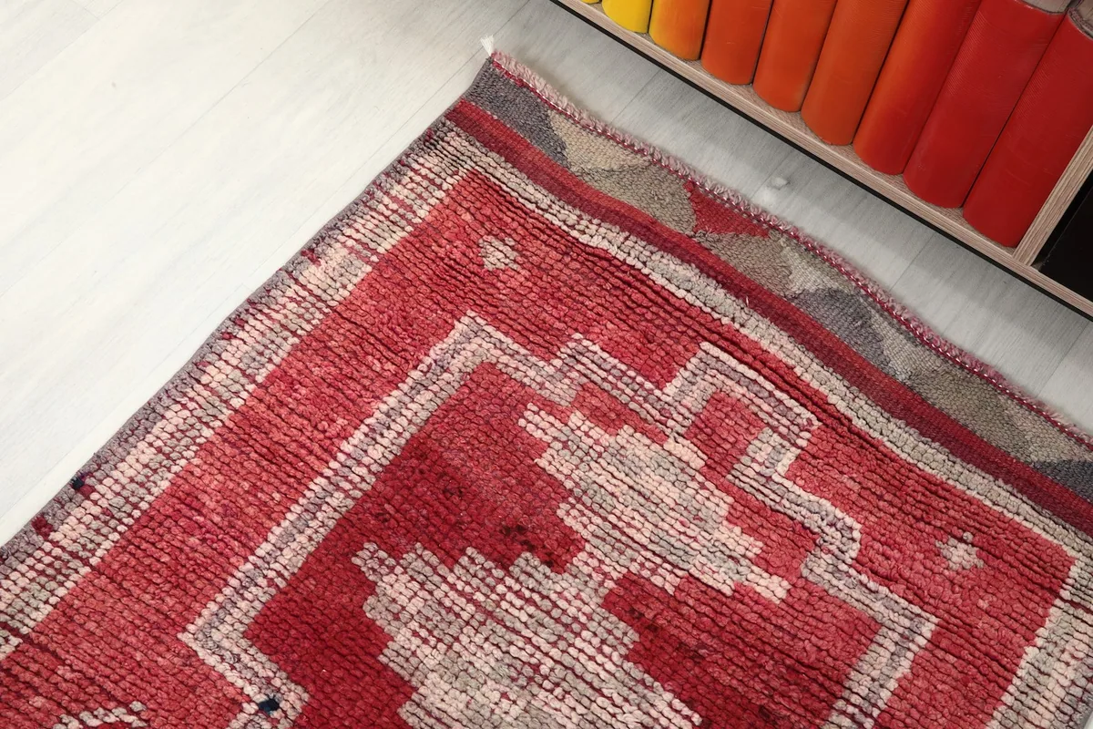 View of the rug's end, showing the geometric border design and color variations