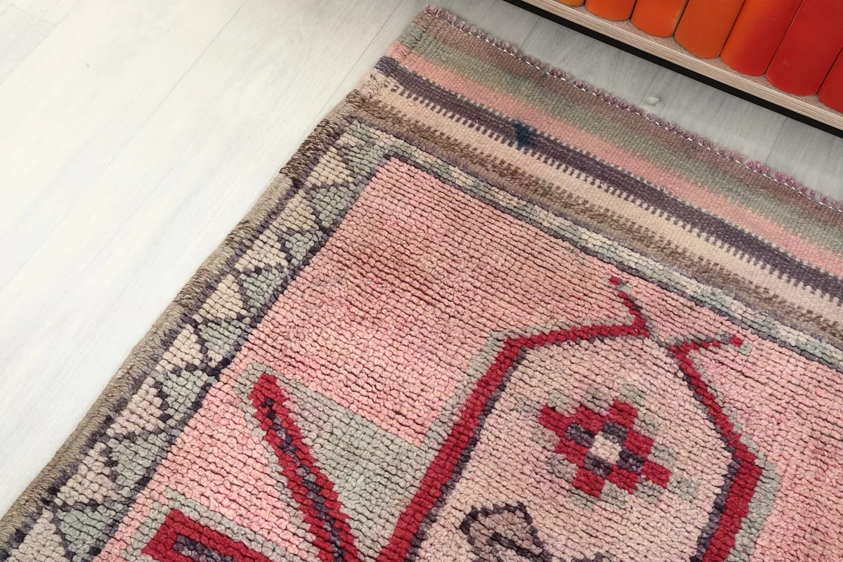 Angle view of the rug's border and end, highlighting the striped finish