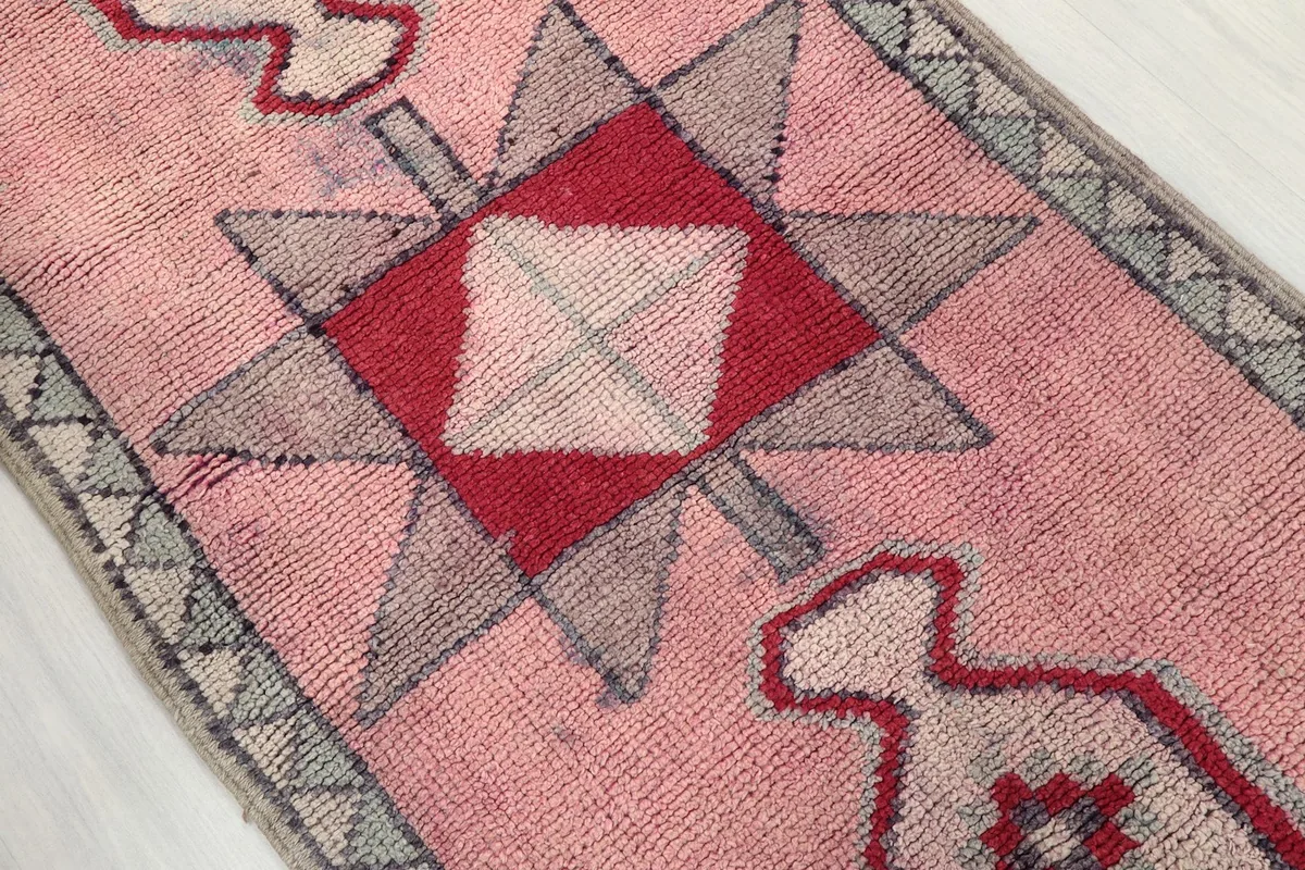 Detail view of the central red and gray geometric motif on the rose runner rug