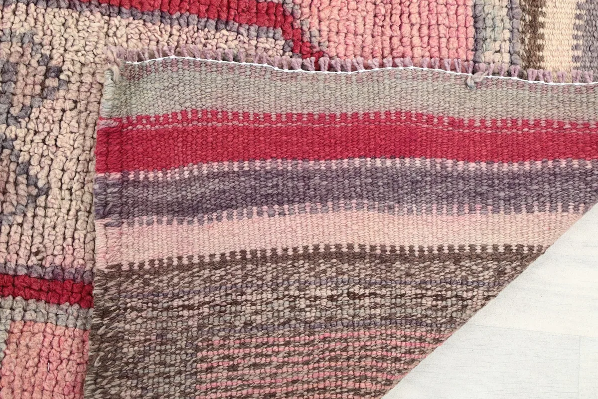 Close-up of the rug's back, revealing the hand-knotted construction and striped ends
