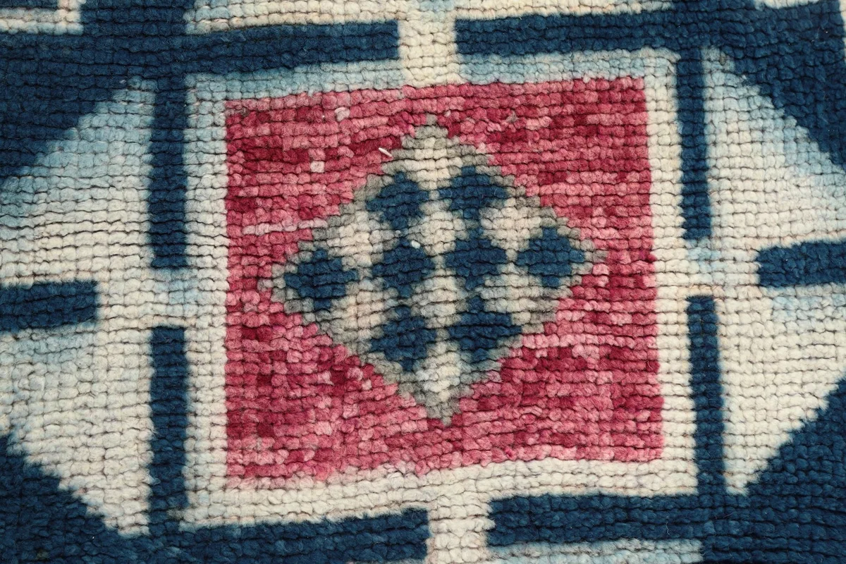 Extreme close-up showing the texture of the hand-knotted wool pile and individual knots.