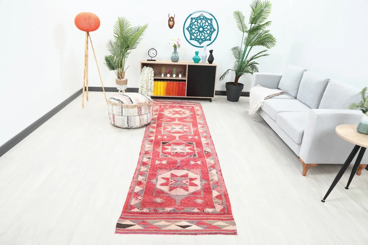 Long red runner rug with geometric patterns in a modern living room setting