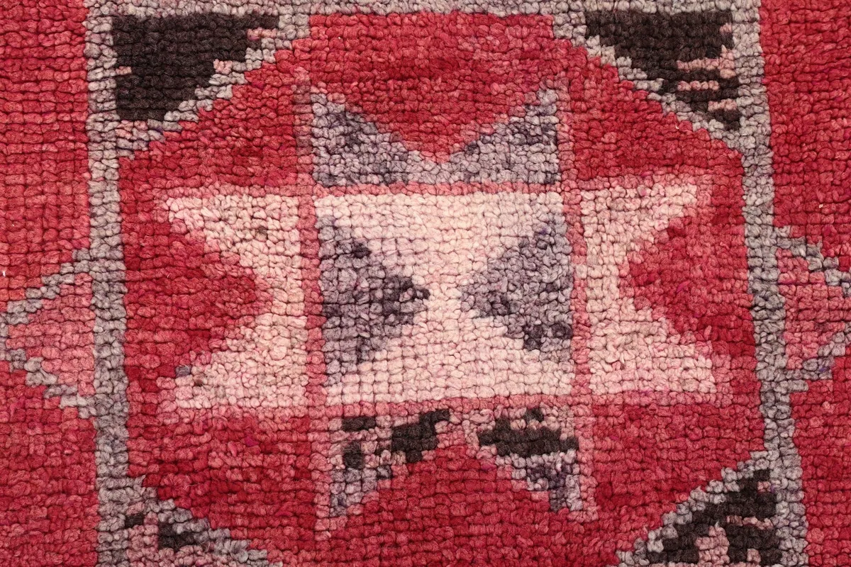 Extreme close-up showing the hand-knotted wool pile and texture of the rug