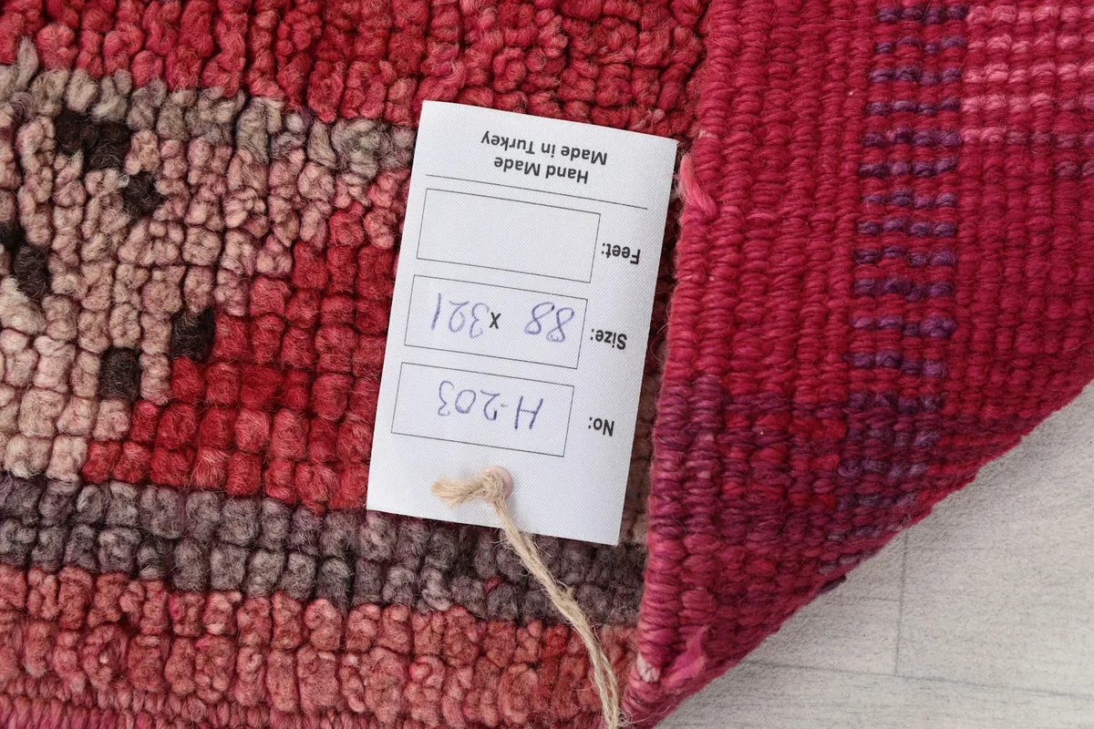 Close-up of the rug's label showing size 88 x 321 cm and origin