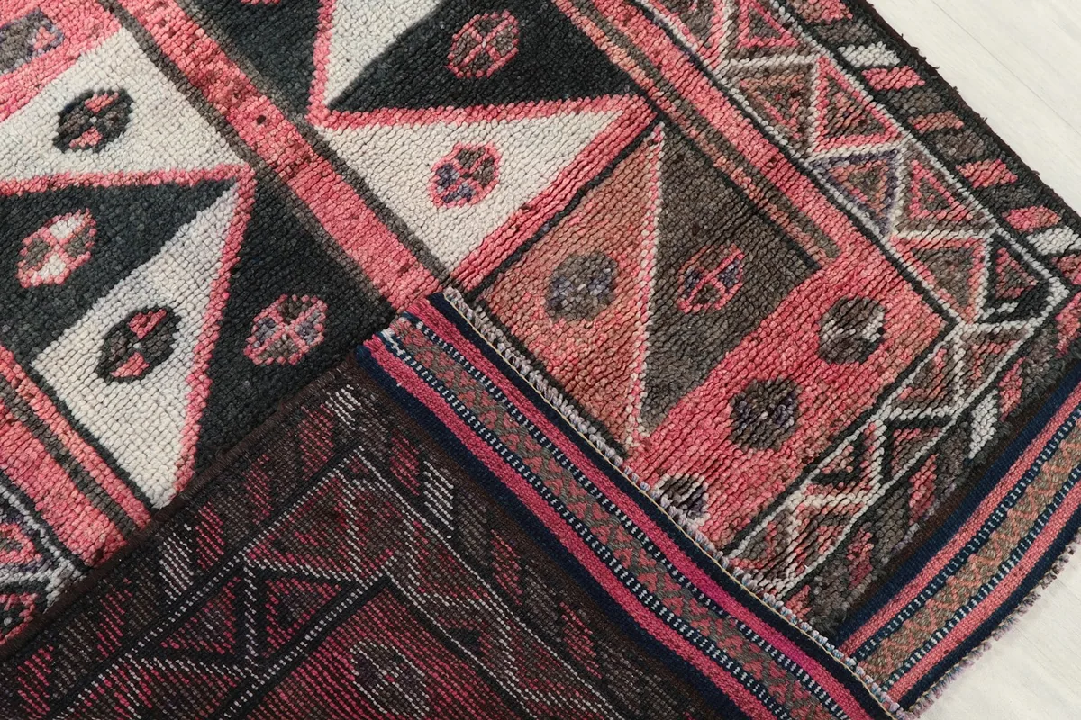 Folded section of the rug revealing the density of the hand-knotted wool pile and reverse side.