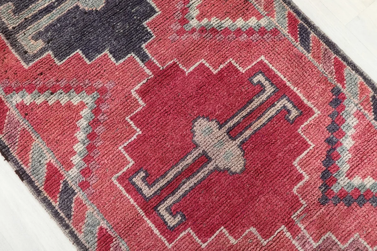 Close-up of a central geometric medallion in rose and gray, highlighting the hand-knotted details