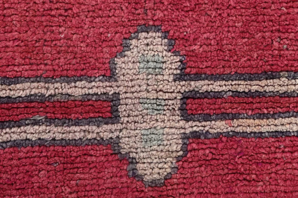 Macro close-up of the wool pile texture and the faded colors of the geometric pattern