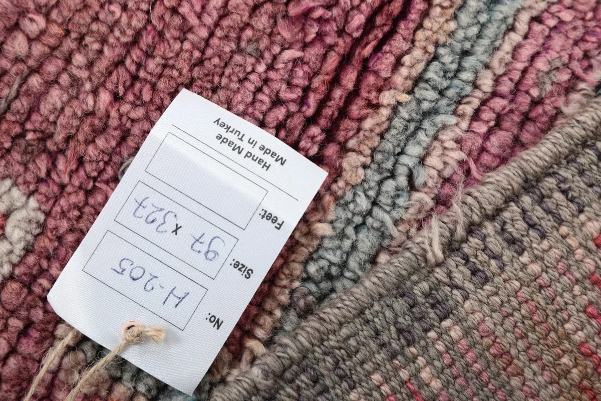 Product tag attached to the rug, displaying item number and dimensions in centimeters and feet