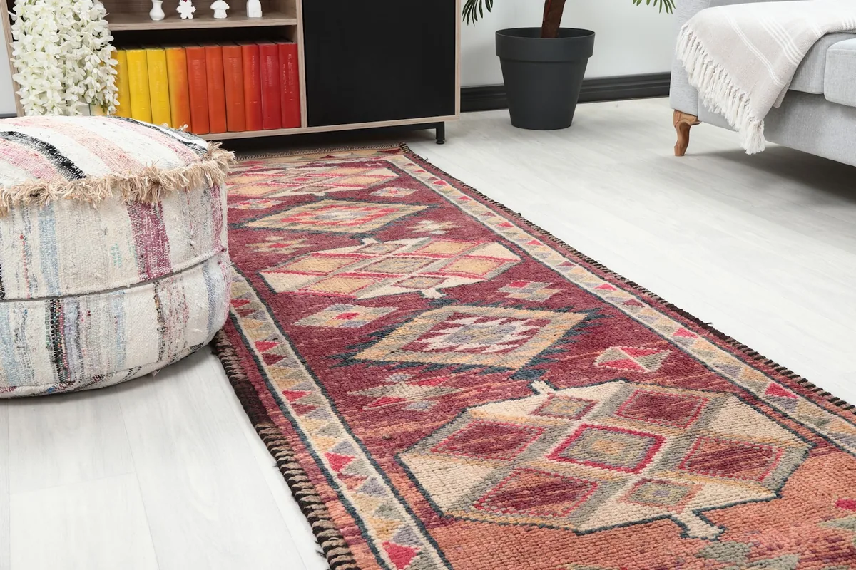 Close-up view of the rust and red runner rug in a room with furniture