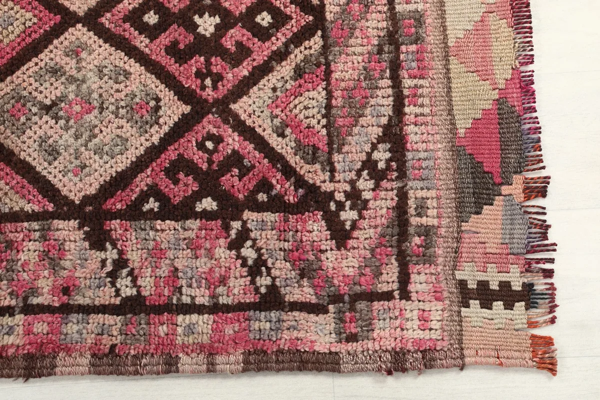 Detailed view of the rug's end, highlighting the hand-knotted pile and fringe.