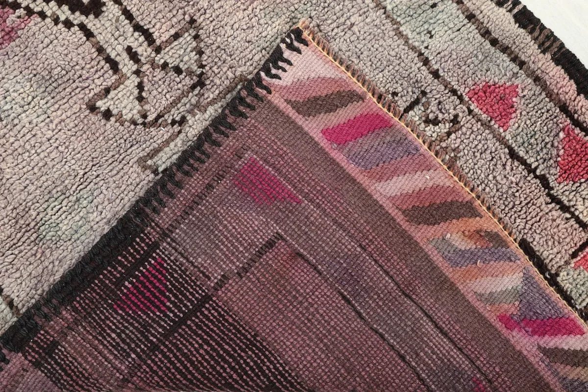 View of the back of the rug revealing the hand-knotted cotton foundation and wool pile construction