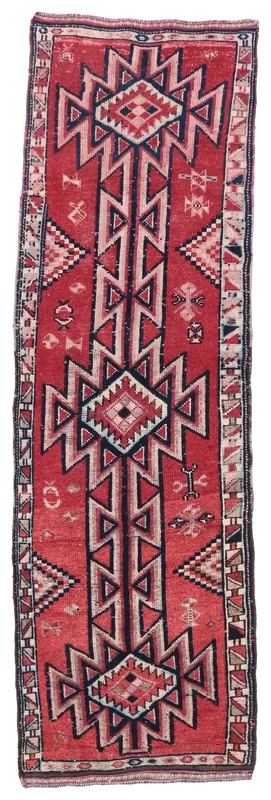 Full overhead view of the red, navy, and beige geometric vintage runner rug on a white background.