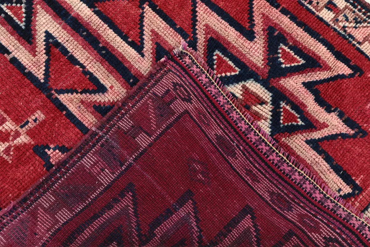 Folded section of the rug, revealing the dense knotting and the back of the hand-knotted construction.