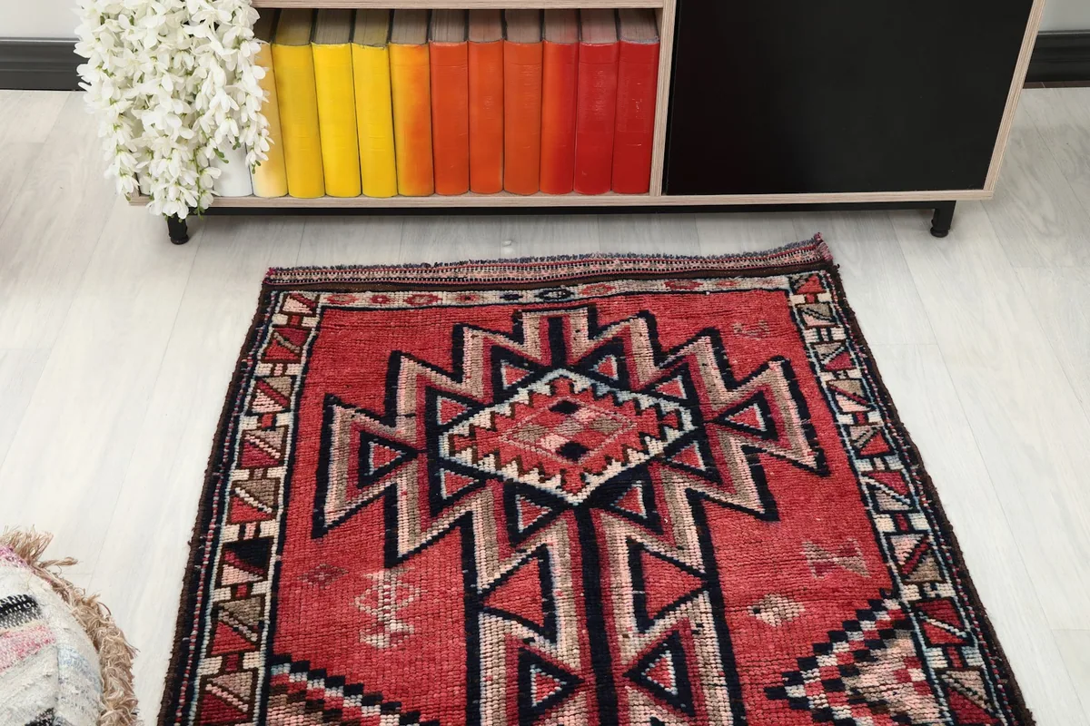 Overhead view of a section of the runner rug, showing the central design and colors in a room.