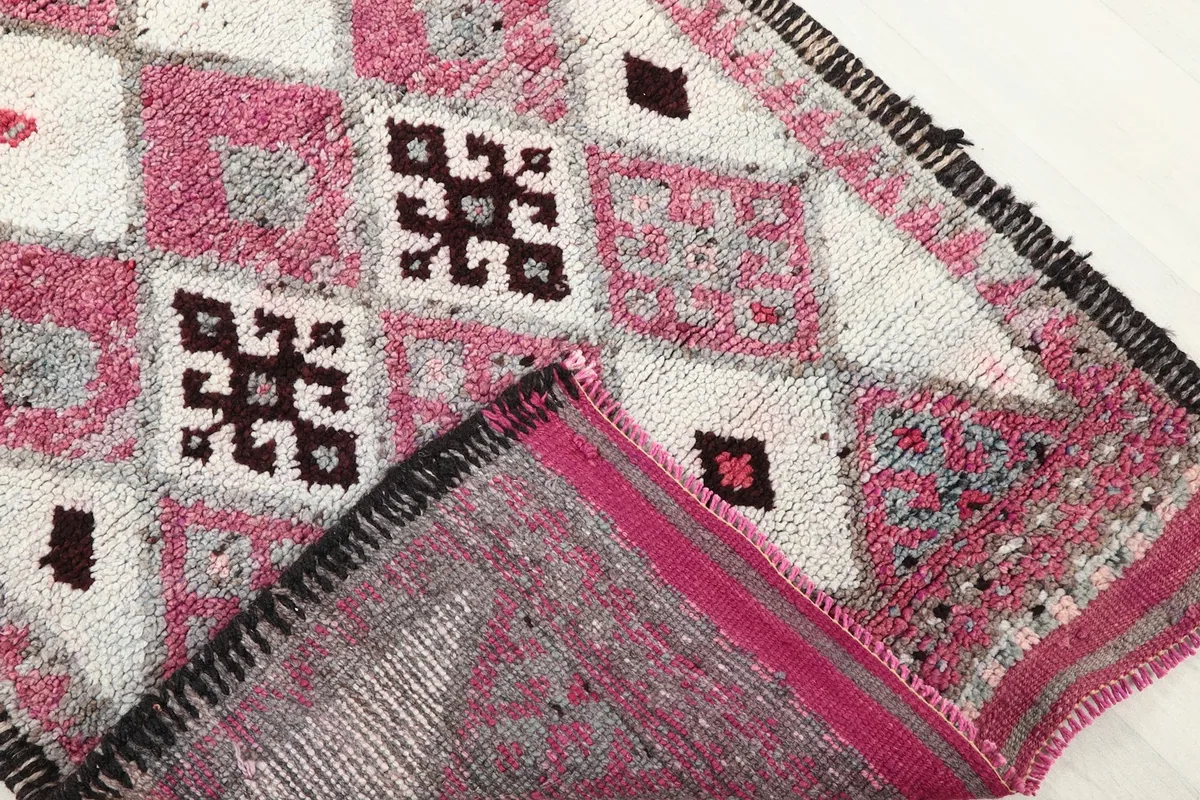 Corner of the runner folded to reveal the cotton foundation and knotting on the reverse side.