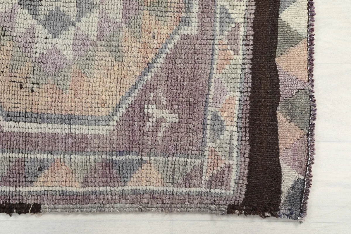Detailed view of the geometric patterns and border on the rug