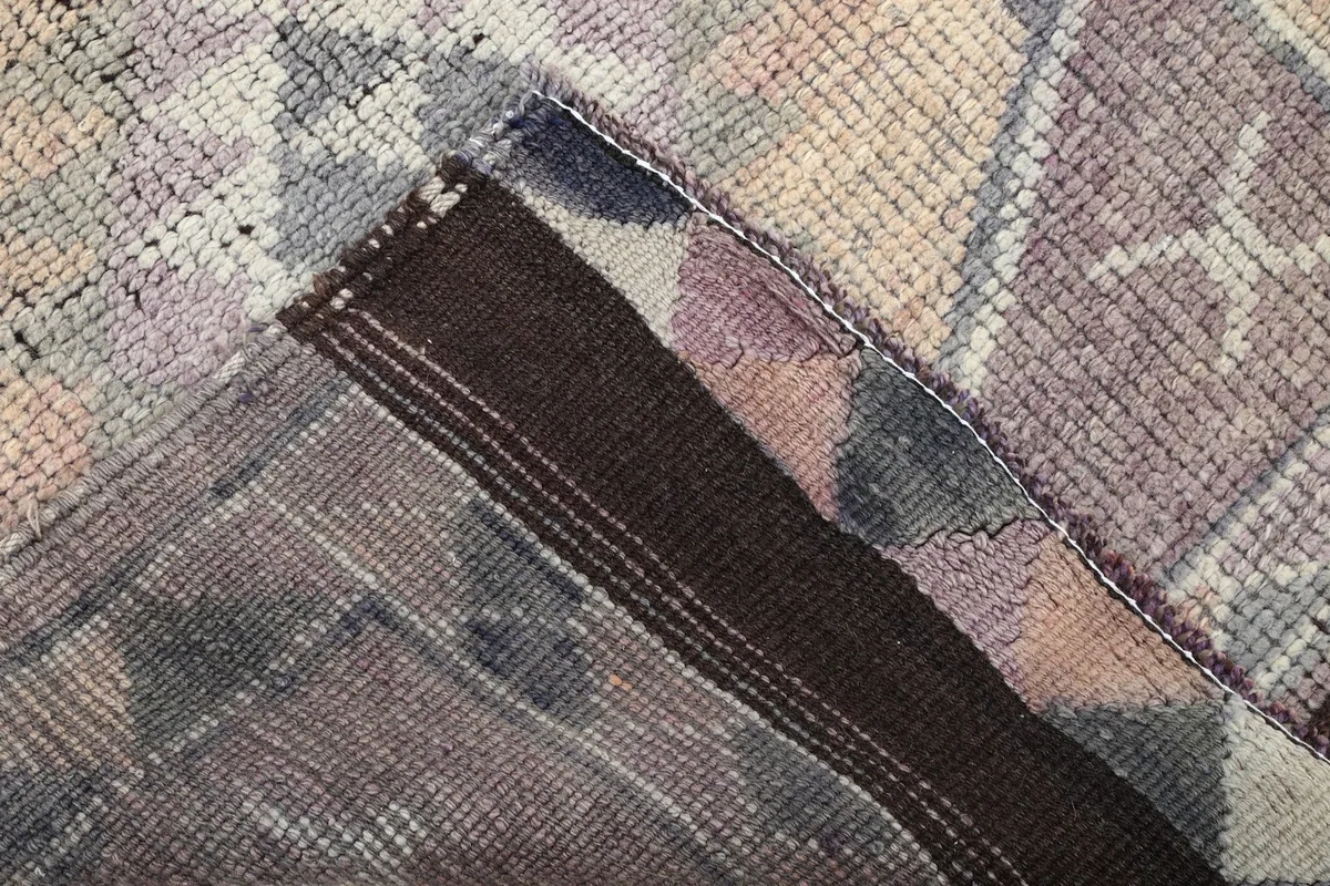 Close-up of the back of the hand-knotted rug showing its cotton foundation