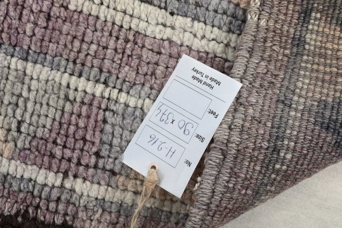 View of the product tag attached to the rug, showing size information