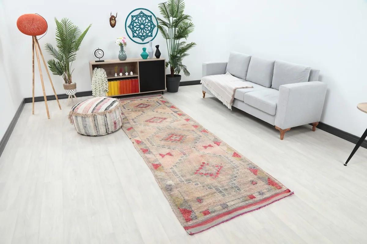 Angle view of the runner rug in a room, highlighting its position next to a sofa and ottoman.