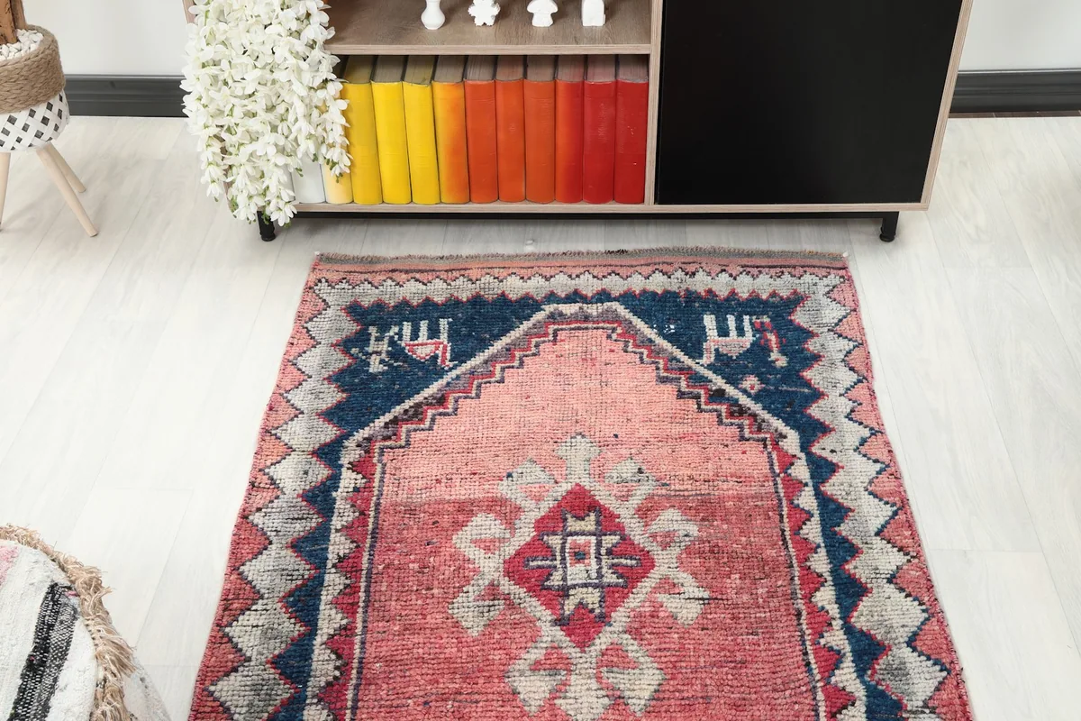 View of the rug's end with navy and cream geometric patterns, placed in a room