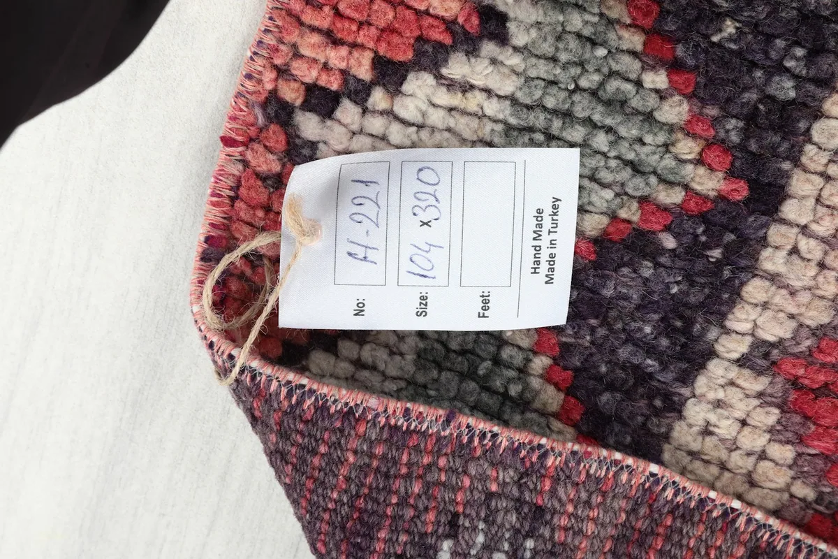 Product tag on the back of the rug, indicating its size, material, and origin