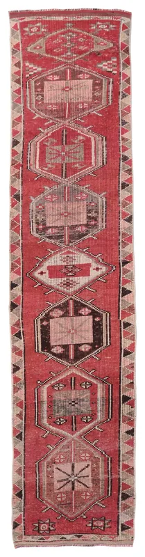 Full overhead view of the vintage red tribal geometric runner on a white background