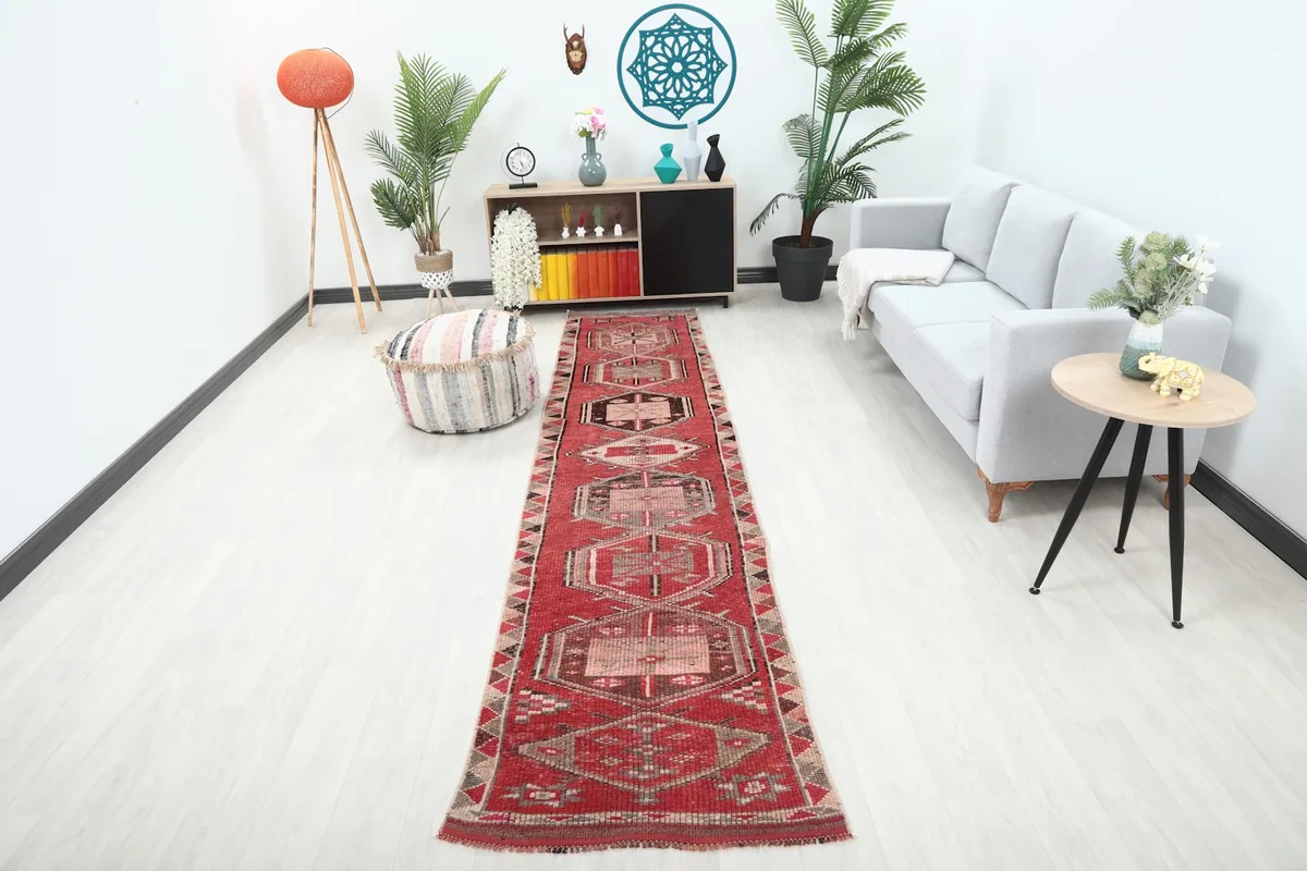 Vintage red runner displayed in a modern living space with a gray sofa and plant decor