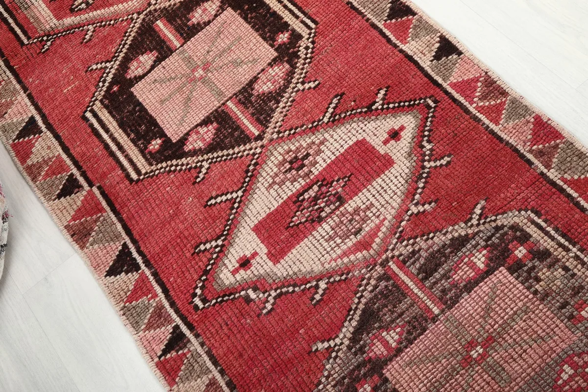 Close-up of the center geometric medallion in red, beige, and brown tones