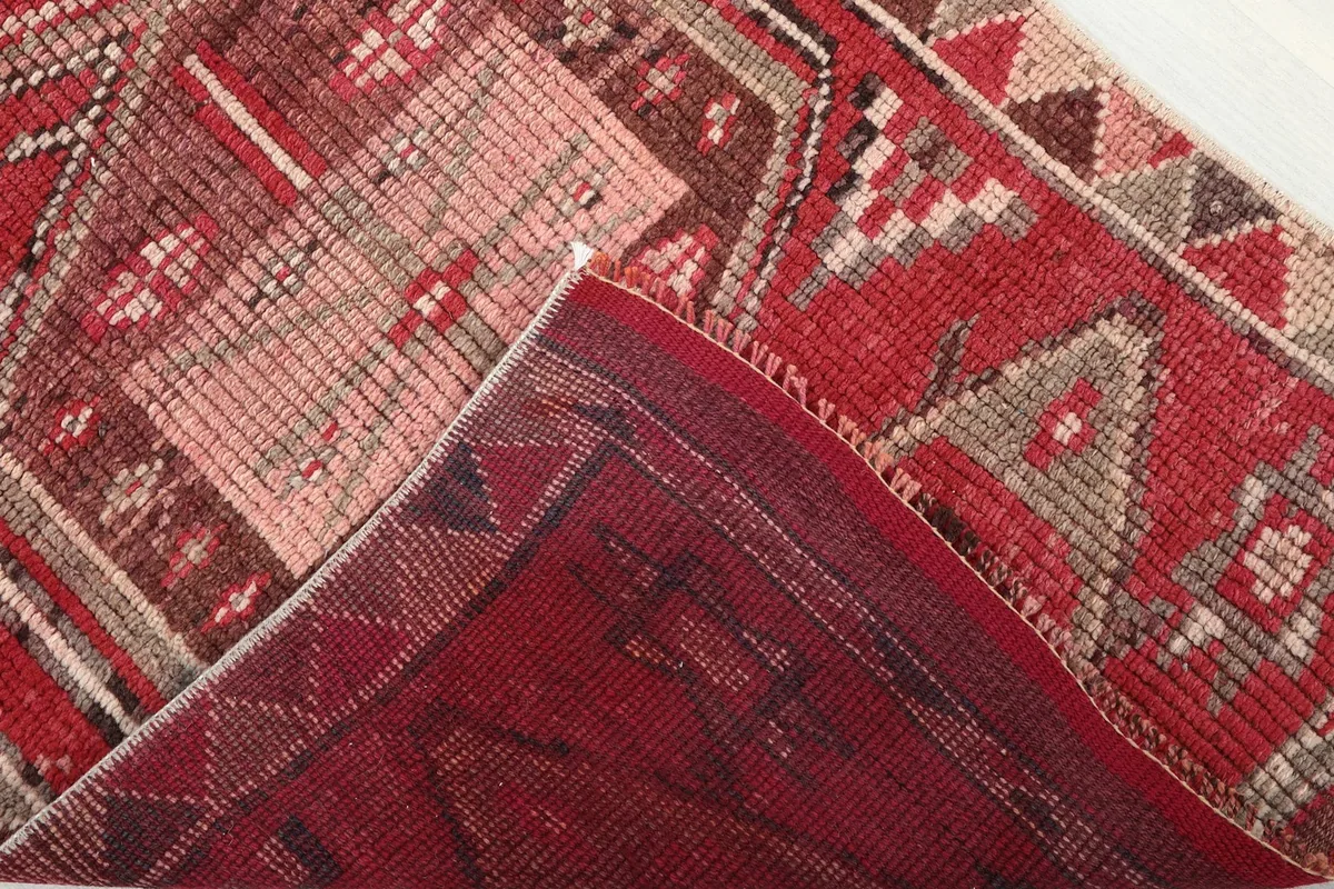 Folded corner revealing the back of the hand-knotted wool runner and cotton foundation