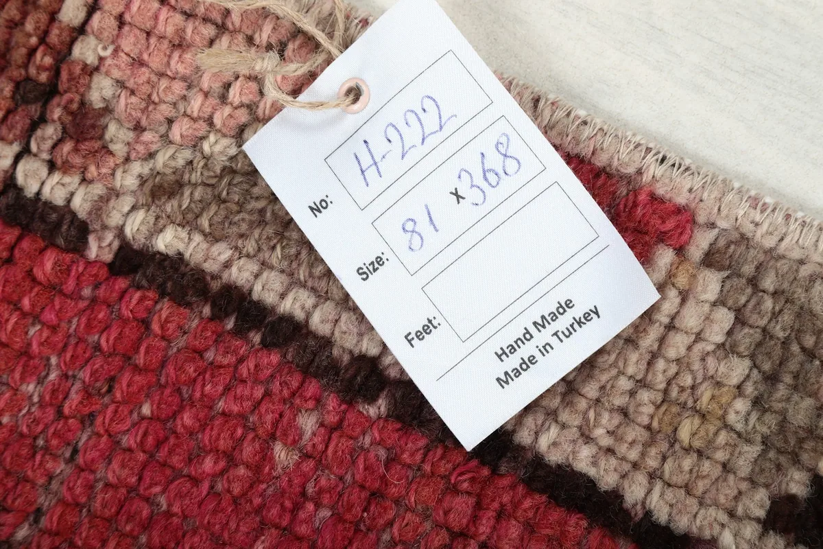 Tag showing the rug's dimensions in centimeters and feet, confirming it is handmade in Turkey