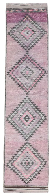 Full overhead view of the vintage rose and purple geometric runner rug on a white background