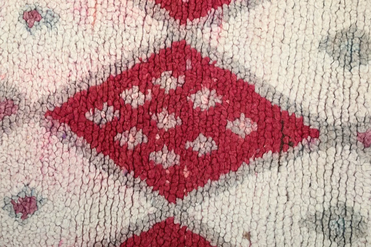 Close-up of the low wool pile texture and a prominent red diamond motif