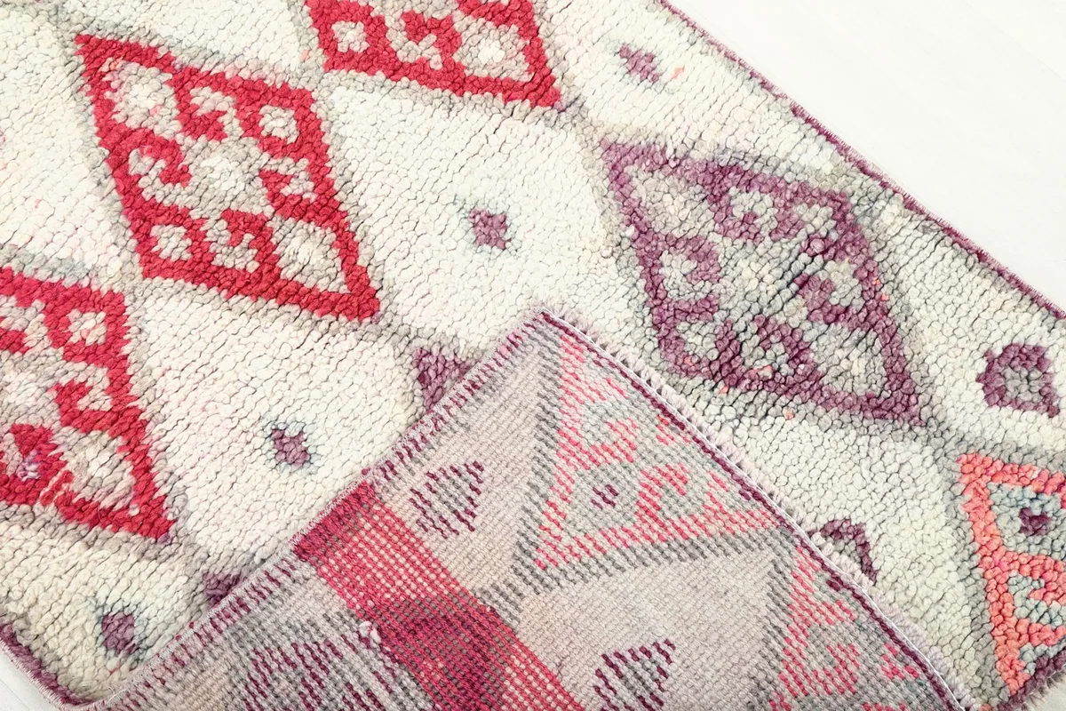 View of the reverse side of the rug, showing the cotton foundation and knotting