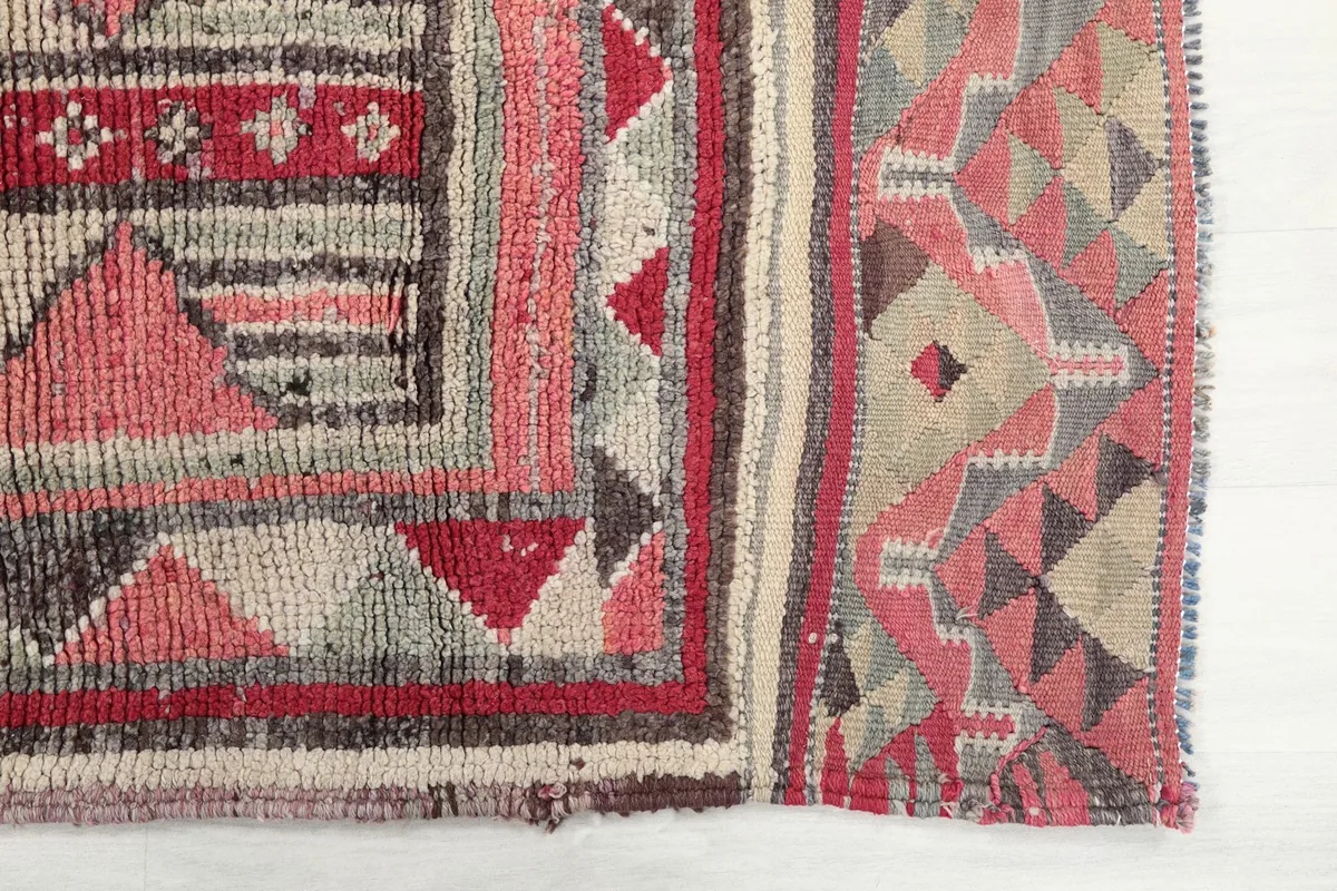 Detailed view of the hand-knotted texture and geometric motifs on the rug's surface