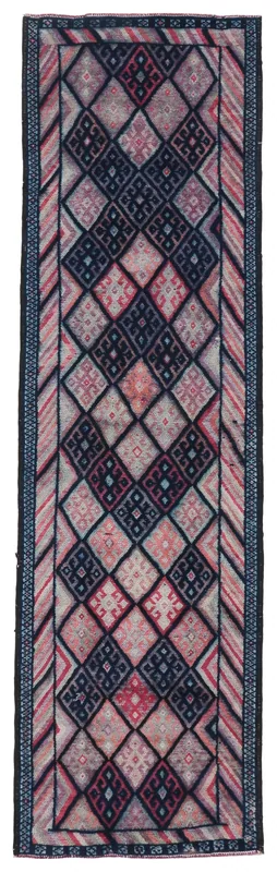 Full overhead view of a vintage navy and rose geometric runner rug on a white background