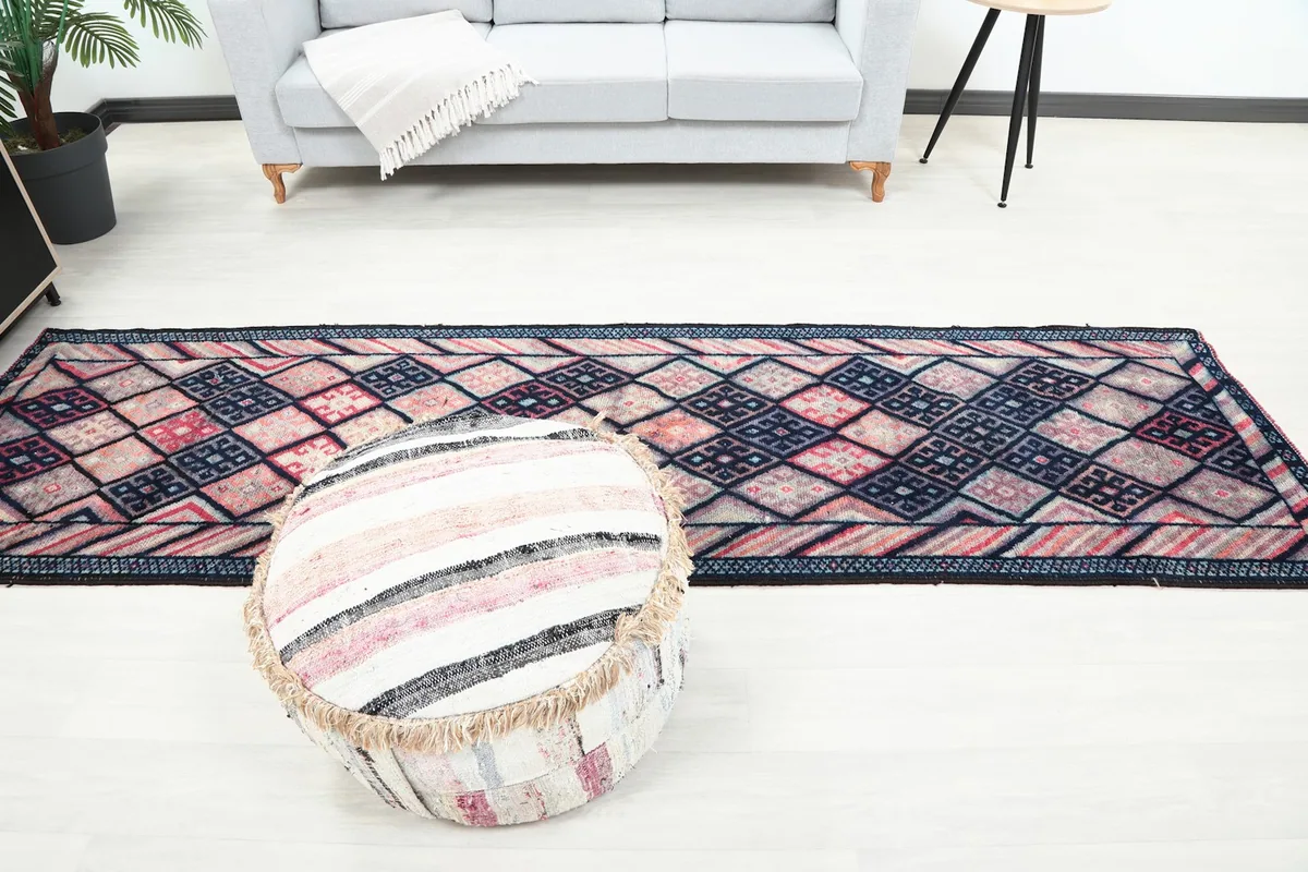 Overhead view of the runner rug with a round ottoman in the foreground, showing its full design