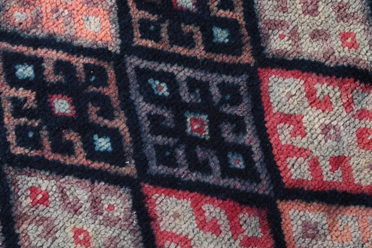 Extreme close-up of the low wool pile, highlighting individual knots and color blending