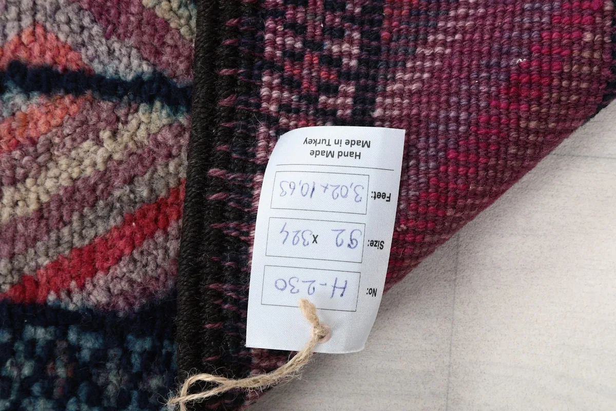 Close-up of the rug's label attached to the back, showing size and origin details